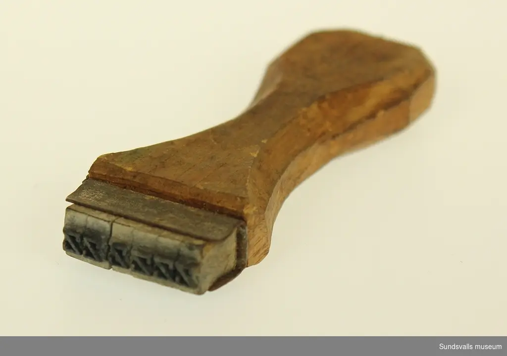 Beskrivning Stämpel med handtag av trä, tryckytan av gummi.