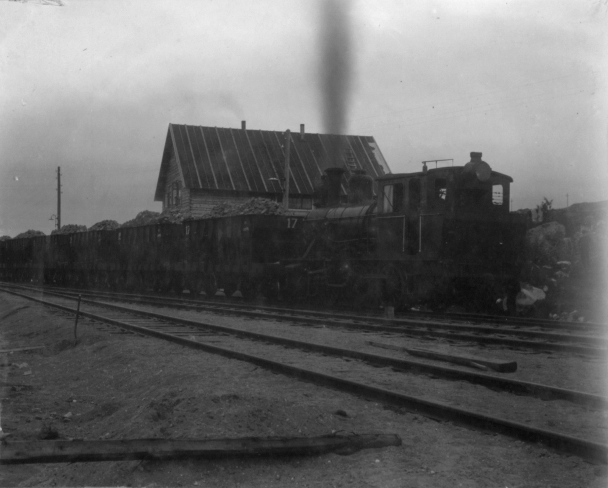 Lokomotiv og vogn. 13/7 1910. Vognene er lastet til det fulle. I bakgrunnen kan man se et hus.
