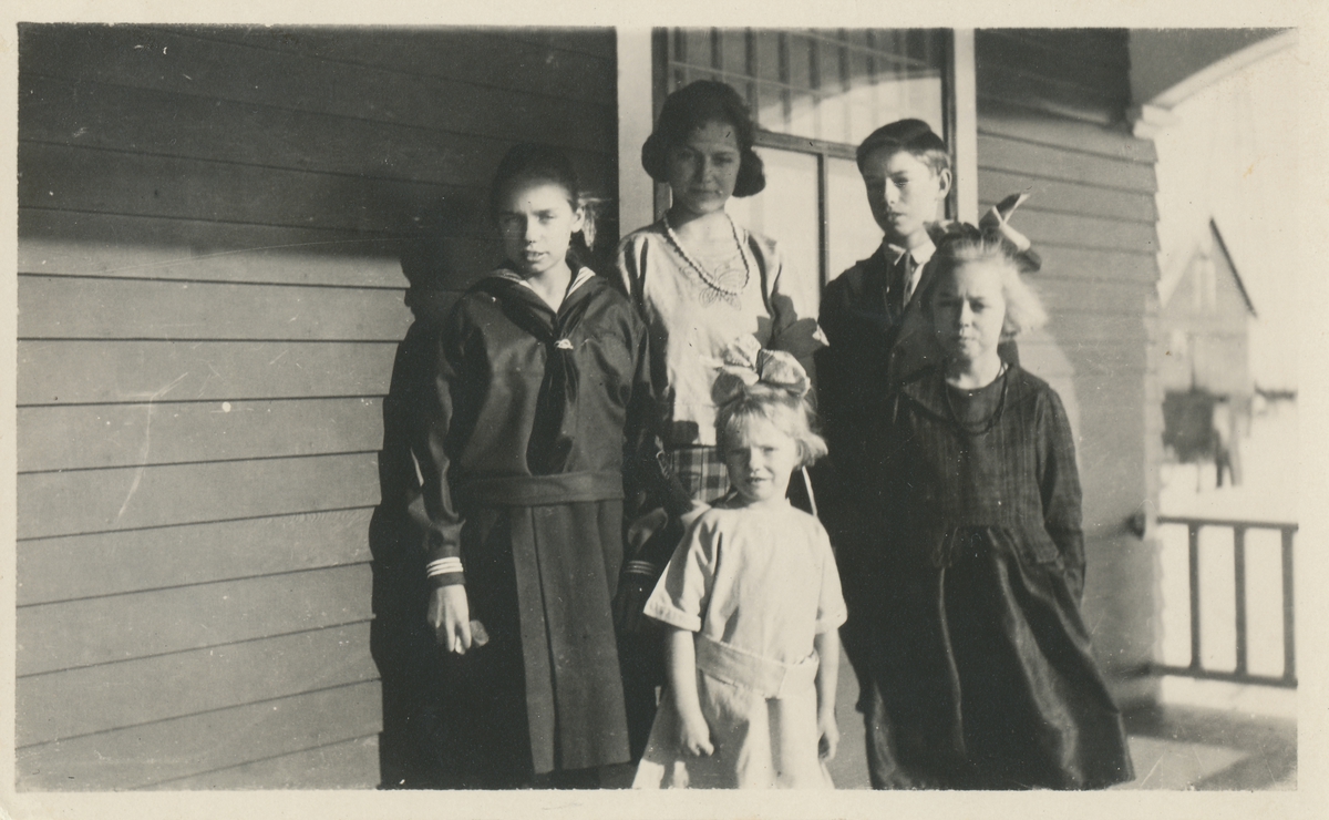 En barneflokk foran et hus i Amerika. Fire jenter og en gutt, slektninger av Skjeldrup.