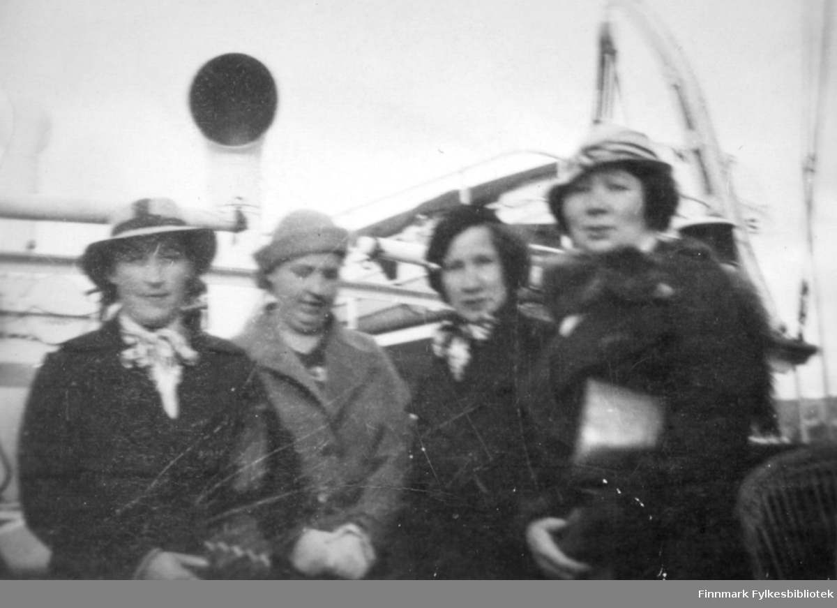 Fire damer fotografert ved et skip. Til venstre på bildet står Gudrun Bauna. Sted og de andre kvinnene er ukjent.