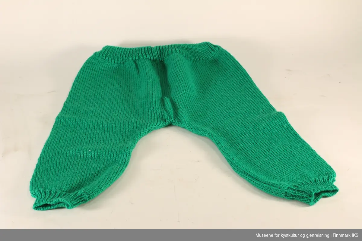 Barnegenser og barnebukser av ull. Buksene er grønne, mens genseren er stripet i grønn og hvit. Genseren er med rund hals og lange ermer.