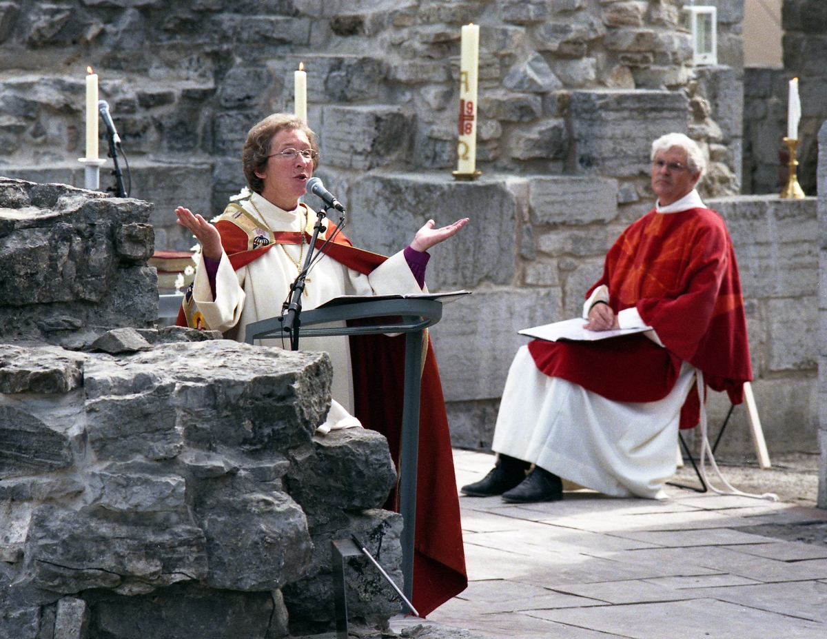 Åpning av vernebygget over Domkirkeruinen på Domkirkeodden, Hamardomen, 9. august 1998, biskop Rosemarie Køhn holder preken. Domprost Ole Elias Holck, sitter i bakgrunn.