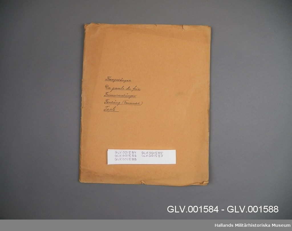 Mappen ingår i samling av fem mappar GLV.001584 - GLV.001588. Mappen innehåller handskrivna noter för basstämman till två musikstycken: Fansång (Fanmarsch) av Wennerberg och Frimurare-Sång.