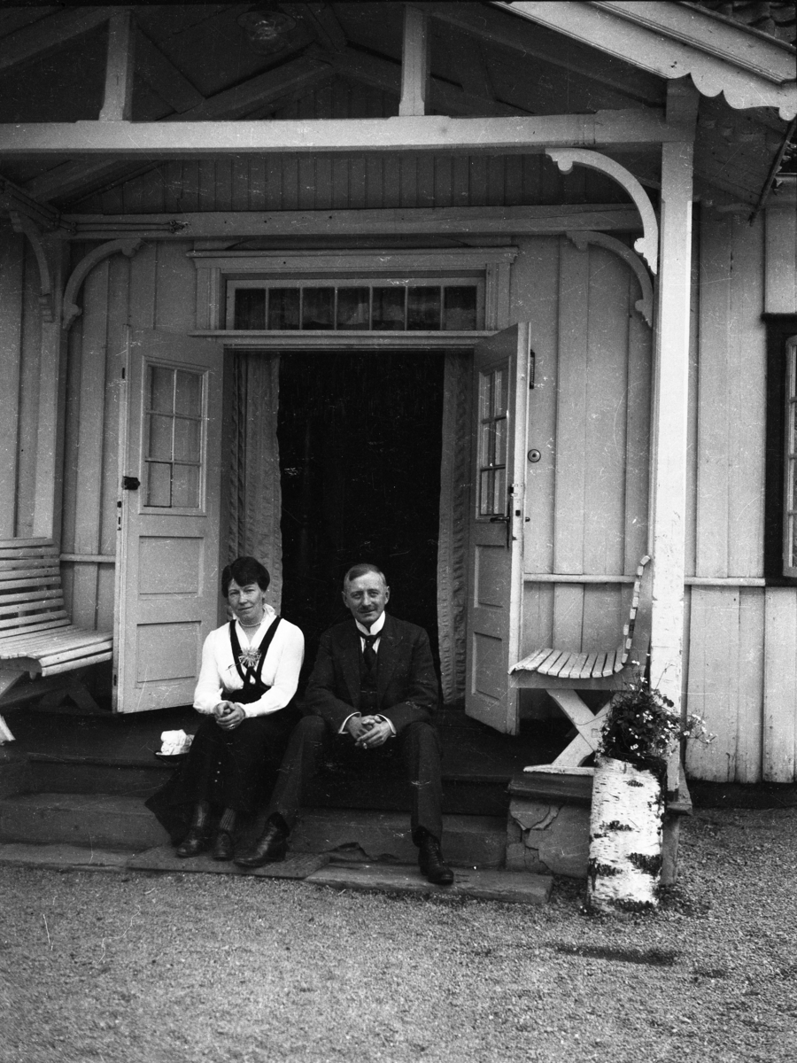 Fotosamling etter Cappelen. Kvinne og mann fotografert sittende på trappen.