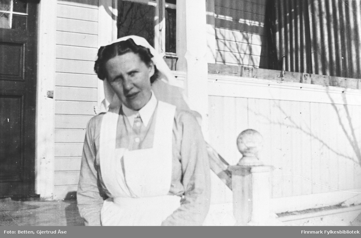 Søster Ingeborg Moan fotografert på verandan til hytta sin i Nyborg. Hun har sykepleieruniform på seg.