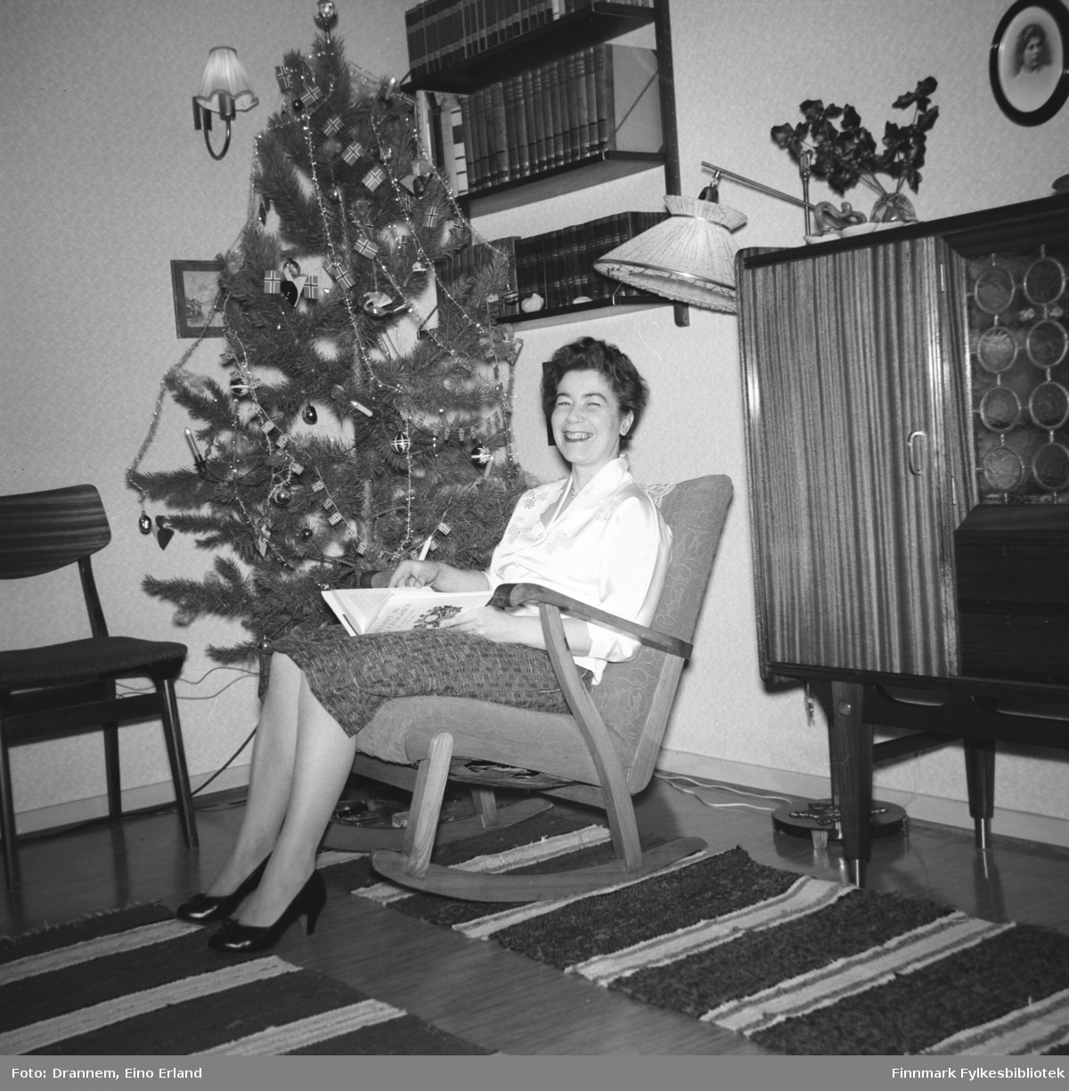 Jenny Drannem sitter i gyngestolen og leser. Det er juletid og familien Drannem har juletræ i stua