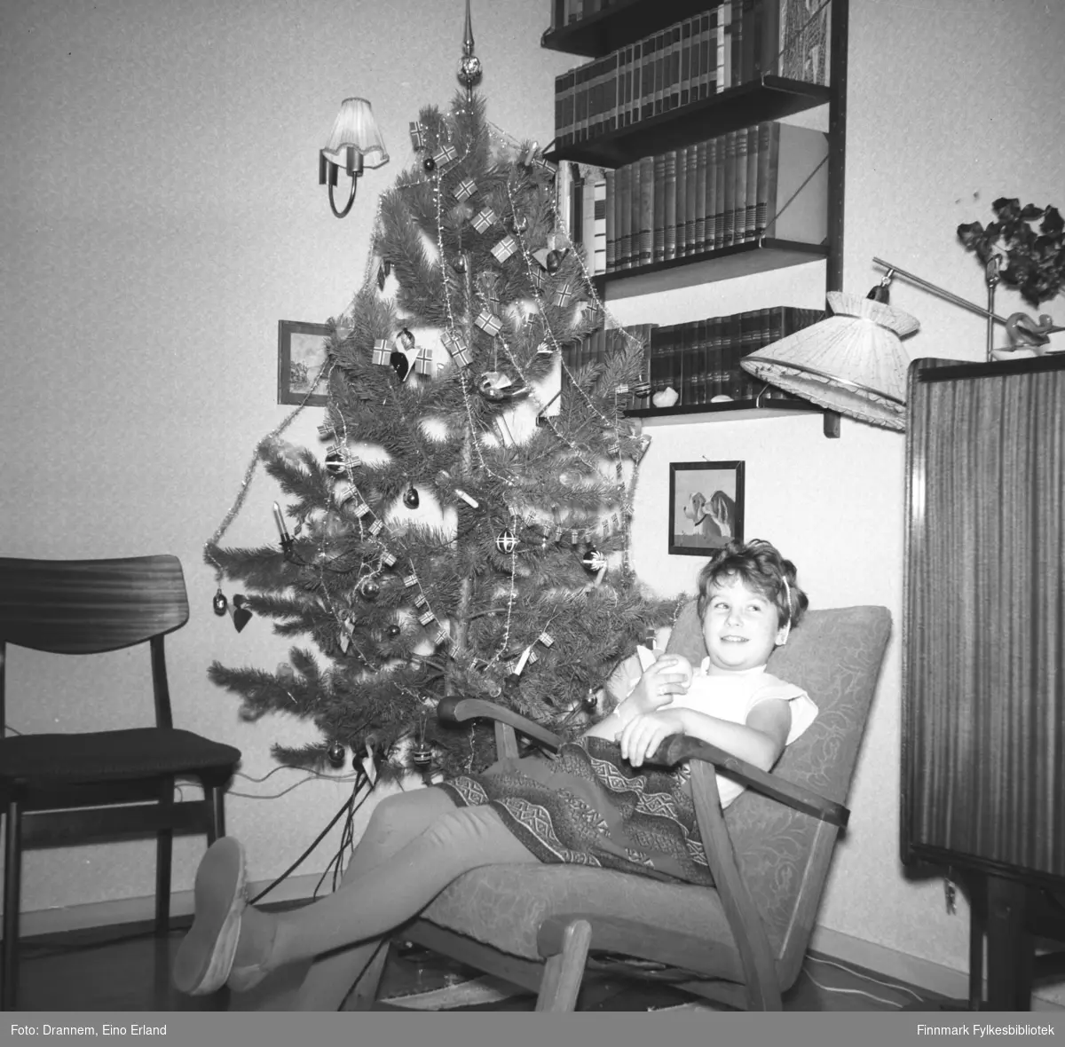Portrett av Turid Lillian sittendes i en gyngestol. Det er juletid og familien Drannem har juletræ i stua