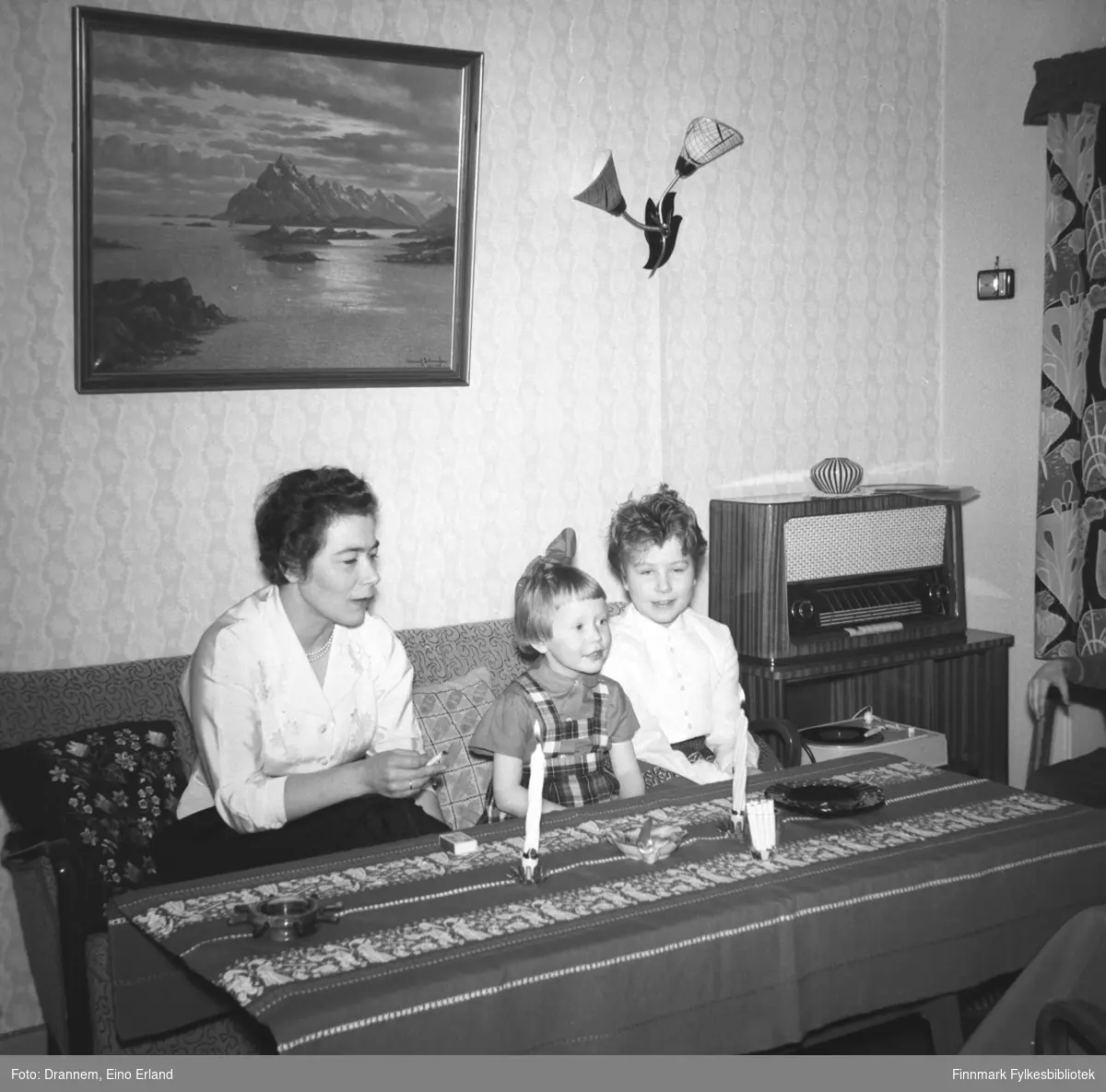 Fra venstre Jenny Drannem, Grete Sørensen og Turid Lillian sitter på en sofa. Det er juletid og bordet er pyntet med to stearinlys og en juleduk