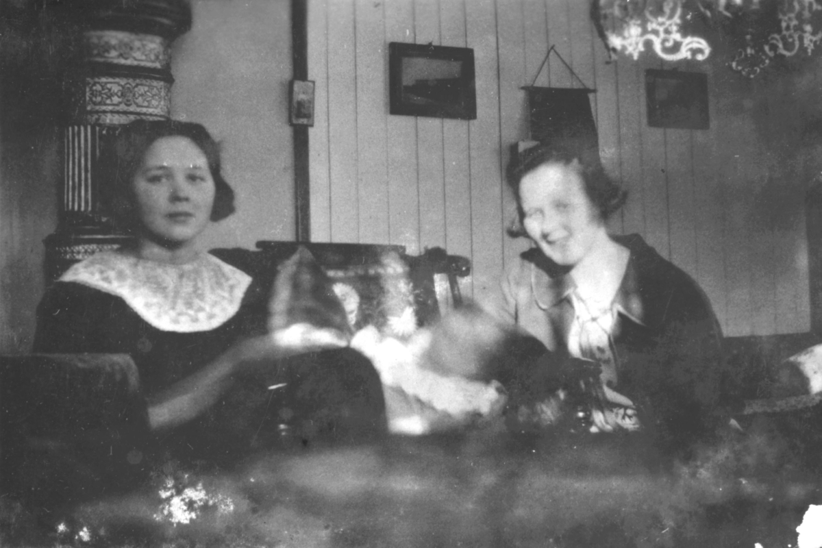 To damer og en baby fotografert i en stue. Damene er Frøydis og Signe, etternavn ukjent. Bildet er sansynligvis tatt i en bolig i Kvalsund kommune før evakueringa.