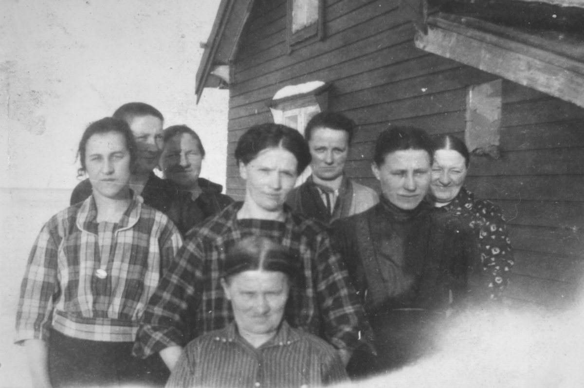 Åtte ukjente personer av begge kjønn med varierende alder fotografert utenfor et hus, sansynligvis i Kvalsund kommune.