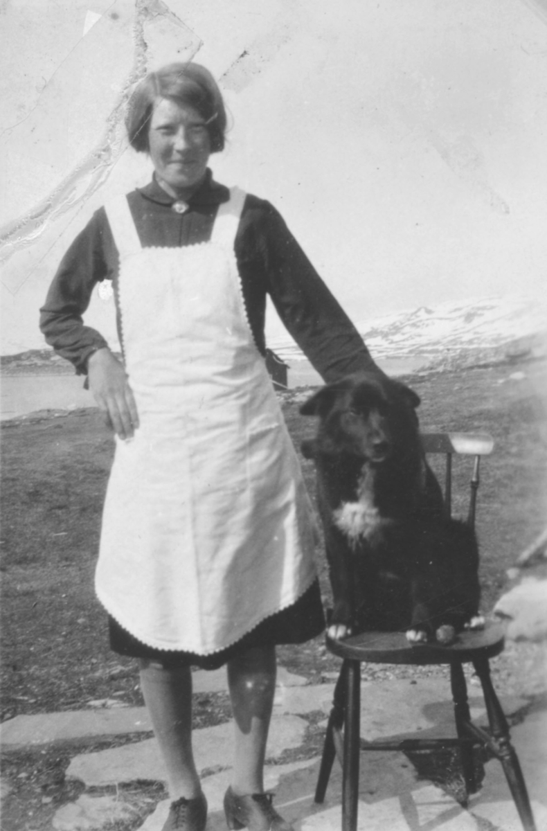 En ung dame fotografert sammen med en hund. Sted og person er ukjent, men bildet kan være tatt i Kvalsund kommune.