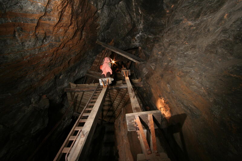 Mann som demonstrerer bruken av mannskapsheisen i gruva.