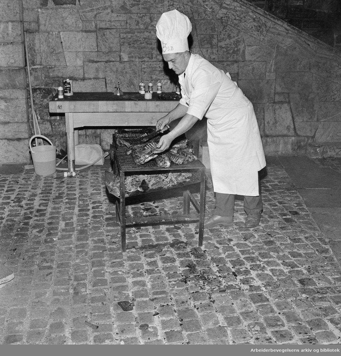 Foreningen Akershus Slotts venner markerer 10 års-jubileum med festmiddag i slottssalen. Bruno Gjerdrum tilbereder maten i borggården. 27. September 1961.