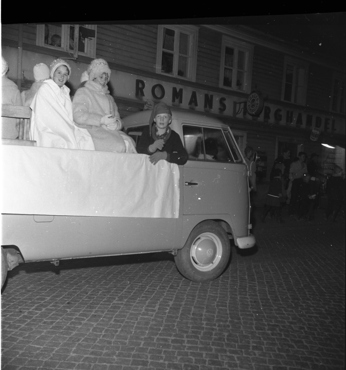 Gränna scoutkårs luciatåg sitter varmt klädda på en VW-pickup på Brahegatan i Gränna. Lucian. En tomtenisse sitter längst fram.