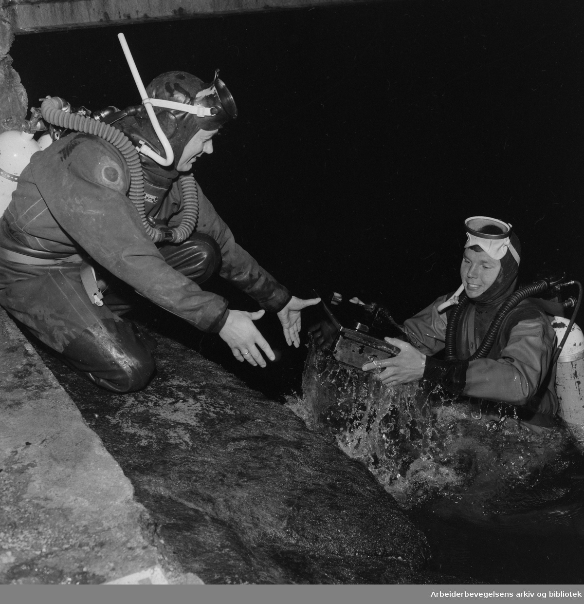 Bjørn Tokerud og Inge Alvik fra Oslo Froskemannsklubb henter opp en stjålet kassa-skuff ved badeplassen på Katten. September 1960.