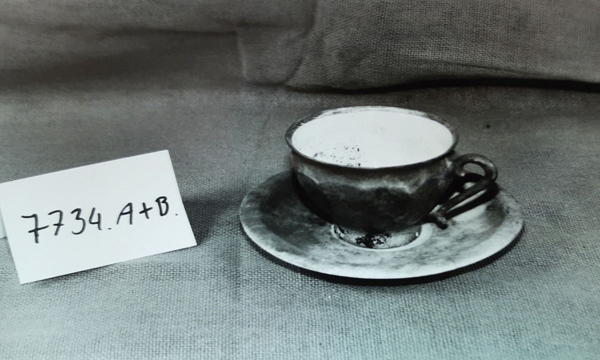 A-B: Kaffekopp m/ skål i keramikk. Buktende form på buken. Bronsefarget.