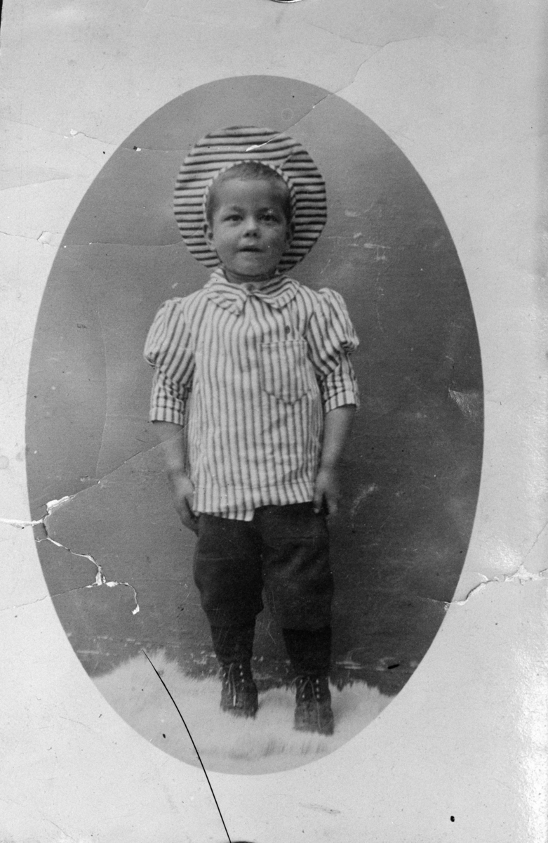 Reprofotografi av en liten gutt i stripete dress og stripete lue.