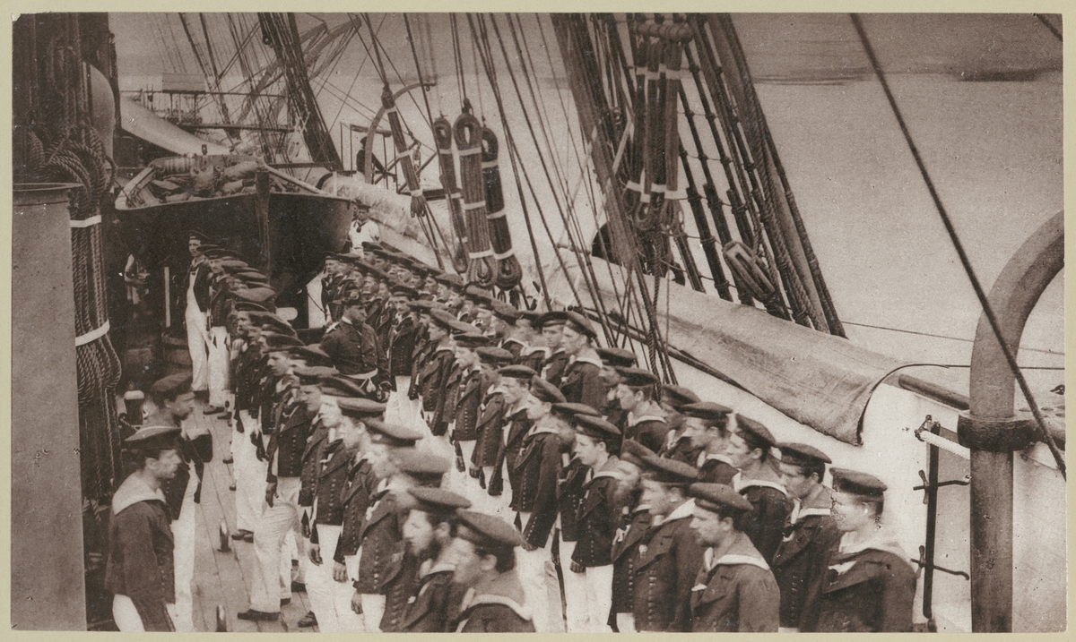 Bilden förställer tyska sjömän ombord på korvetten Stosch som har tagit uppställning för mönstringen som sker varje söndag för att kontrollera den personliga hygienen och städningen i bo utrymmen.