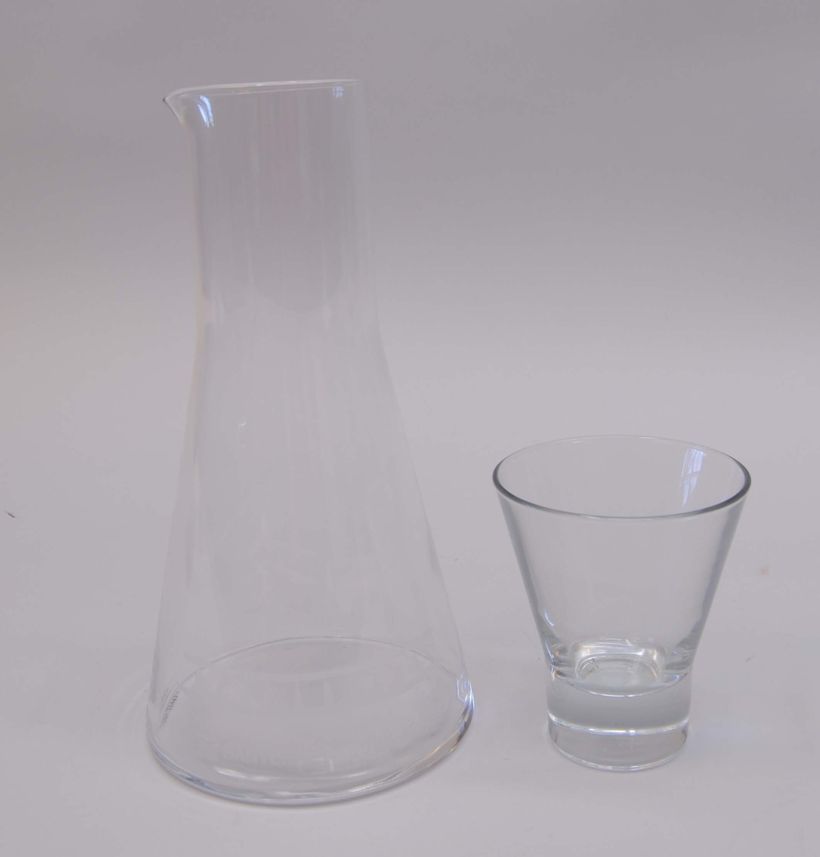Vattenkaraff (:1) av kristallglas med tillhörande dricksglas (:2) som med botten nedåt bildar en kork för karaffen. Karaffen har en liten öppen pip. Karaffen är märkt med Banverkets logotyp samt årtalen 1988-2010. Ovanför är en stiliserad bit av en räls etsad. Glaset har en tjock cylindrisk botten och ovanför botten är glaset utsvängt. Karaffen har en motsvarande form fast svängd nedtill mot botten, och i övre delen är den cylinderformad. Karaffen och glaset har både en klisteretikett med texten "nybro Crystal Sweden".