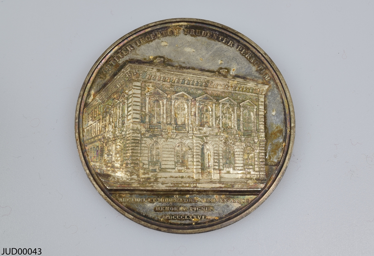 Silvermedalj, som är dekorerad med A.O. Wallenberg i profil på ena sidan. Andra sidan är dekorerad med SEB:s kontor i Stockholm samt med latinsk text.