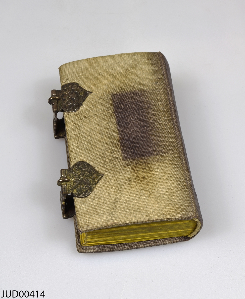 Siddur med canvasklädd träpärm och silverspännen. Boken är tryckt på papper och enligt blyertstext i boken ska den vara tryckt i Amsterdam 1750. Skriven på hebreiska.