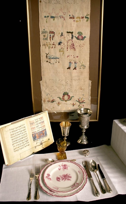 Glasbägare av slipat brunt glas med tjock fot. Etsad dekor i form av hebreisk text och davidsstjärna.