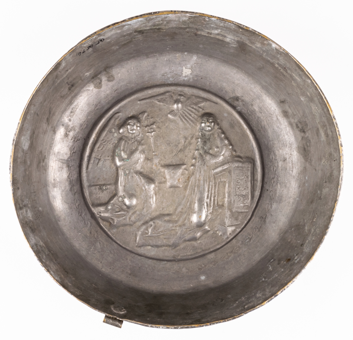 Dopfat av förtent mässing, rund med reliefbild: Marie bebådelse.
Ursprungligen katalogiserad som puddingform, senare ändrat till dopfat.
