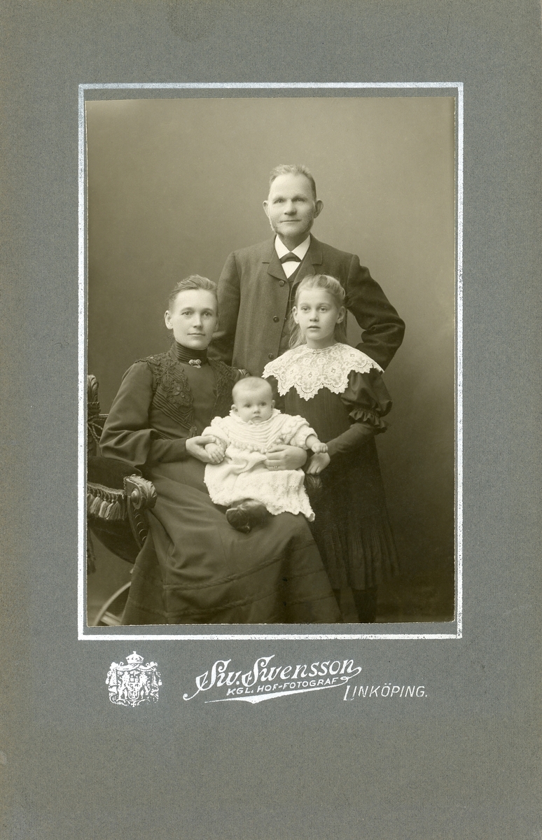 Porträtt av familjen Eriksson omkring 1906. Makarna är Erik och Lovisa Eriksson. Deras döttrar heter Hildur och Karin, den sistnämnda född 1905. Paret hade inflyttat till Linköping från Eskilstuna 1893. Familjen var bosatt i Tannefors där de blev kvarnägare och maken etablerat rörelsen AB Erikssons Valskvarn.