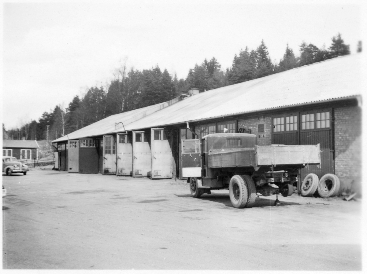 Vägstation F7, Tenhult. Garagebyggnad. Framför byggnaden en Scania Vabis lastbil 1938, registreringsnummer F693, uppallad för hjulbyte. Lastbilen tillhörde vid vägväsendets förstatligande Tveta vägdistrikt, fick efter förstatligande maskinnummer VoV A463.