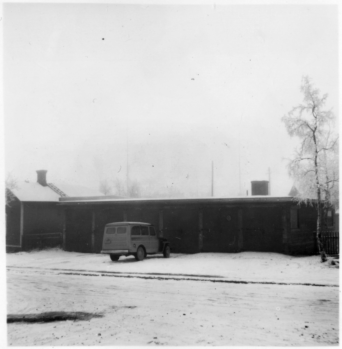 Vägstation BD14, Vittangi, filial Laxforsen. Garagebyggnad. Personbil framför byggnaden (vinterbild).