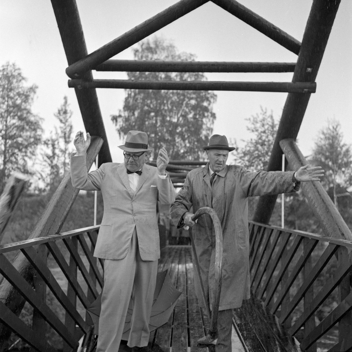 Fra åpningen av brua over Klokkerfossen i Glomma i Elverum (Hedmark) 30. juni 1964. Brua skulle forene det daværende Norsk Skogbruksmuseums friluftsavdeling på Prestøya med et nyerhvervet areal på klokkergarden Fossum, som lå på østsida av elva. De to mannene i forgrunnen er museets styreformann, Hans Th. Kiær (til venstre), og lederen i representantskapet, Eyvind Wisth. Sistnevnte hadde nettopp kappet en 8 meter lang stokk som var lagt på tvers over brua som et symbolsk stengsel. Han utførte denne oppgaven med ei antikvarisk bogesag fra museets samling. Da de to halvdelene av stokken falt i fossen, på hver sin side av brua, skal Wisth ha deklamert følgende godt forberedte utsagn: «Denne symbolske handling betyr et tidsskifte, og den nye brua binder museets samlinger på Klokkergården sammen med det egenartede miljø som er skapt på Prestøya. Den åpner for nye muligheter i den videre utvikling og gjør Skogbruksmuseet til sin egen herre.» Det siste refererte antakelig til at Norsk Skogbruksmuseums friluftsavdeling med dette ble tilgjengelig uavhengig av Glomdalsmuseet, fra en ny innkjørsel mot Solørvegen på østsida av Glomma. 

Arbeidet for å få bygd bru over Klokkerfossen startet i 1961, samtidig med at det ble igangsatt en prosess for å skaffe Norsk Skogbruksmuseum arealer for videreutvikling av virksomheten på østsida av Glomma. Museet søkte råd ved Hedmark vegkontor og i Glomma fellesfløtingsforening. Fløtingsforeningen krevde at brulegemets underkant måtte plasseres minst en meter over den høyden 1934-flommen hadde hatt. Grunnarbeidet ble påbegynt i 1963. Da forelå det tre ulike alternativer for hvordan brua skulle bygges. Det lokale entreprenørselskapet Martin M. Bakken tilbød en heltrekonstruksjon, Moelven Brug kunne levere en limtrekonstruksjon og Norsk Gjærde- og Metalldukfabrikk lanserte ei hengebru i stål. Arbeidsutvalget fra museets styre gikk enn for en såkalt tømmersprengverkskonstruksjon som arkitektfirmaet Arkitim på Hamar hadde modellert. Denne løsningen ble valgt både fordi den var prisgunstig, fordi tømmerkonstruksjonen var estetisk tiltalende og fordi materialet passet godt på et Skogbruksmuseum. Brua fikk fire spenn mellom frittstående støpte brukar samt mot støpte landkar. Den samlete lengden ble 108 meter. Det kostet 155 000 kroner å få reist dette bindeleddet mellom Prestøya og det nye museumsmrådet på klokkergarden Fossum. Trekonstruksjonene i brua ble fornyet i 2005.