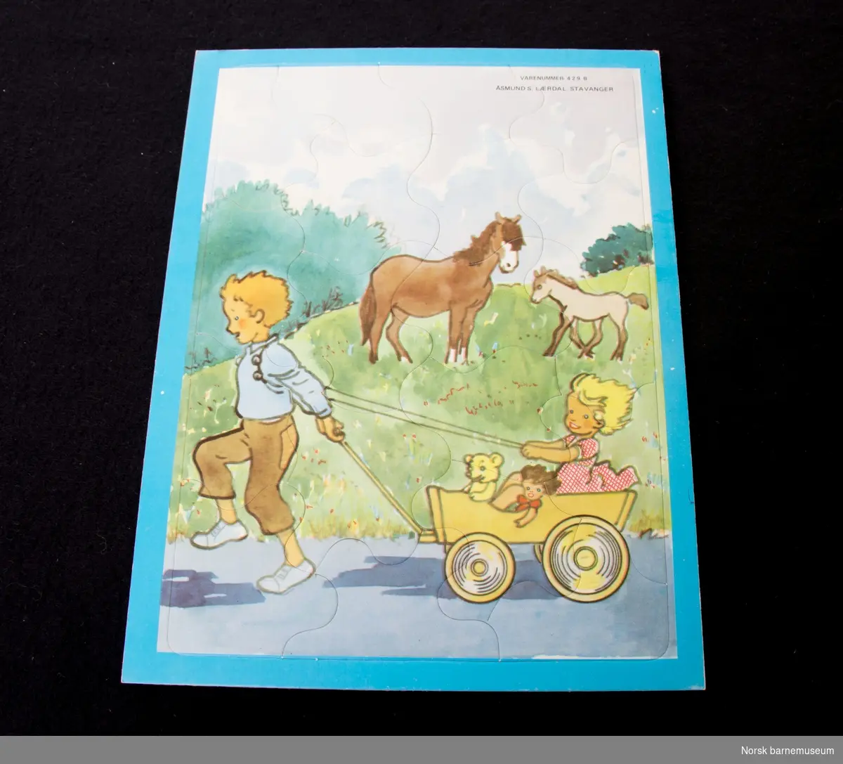 Puslespillet er laget som et bilde av en gut som drar en jente i en vogn. 