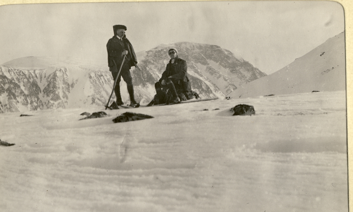 To skigåere (Westye Egeberg til venstre?) raster på bandet mellom Veodalen og Blåtjernshøle(?) i Jotunheimen. Fotografert påsken 1910.