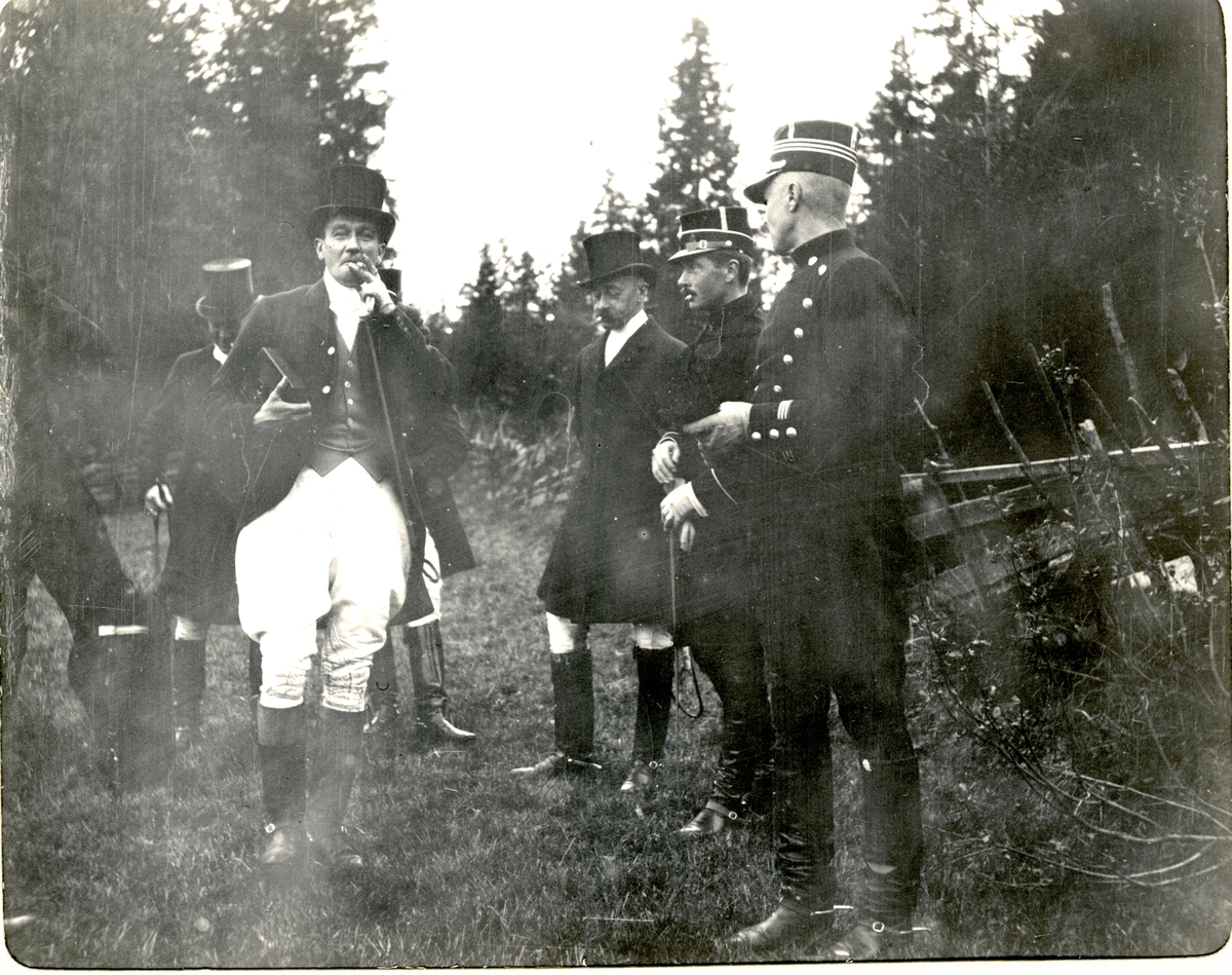 Seks menn tar en pause under jaktritt på Fritzøe i Larvik. Forrest fra venstre Thomas Fearnley, Chr. Fr. Michelet, Fritz Treschow, og rittmester Smith Kielland. Fotografert 1910.