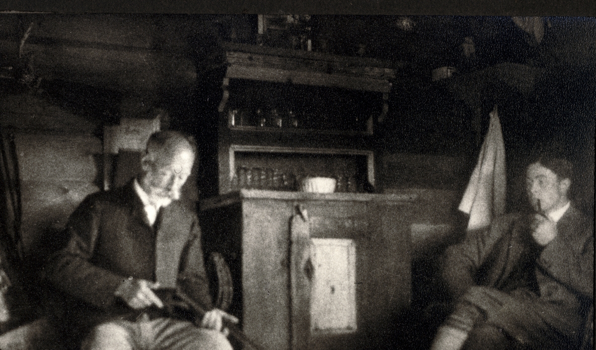 Ferdinand J. Egeberg pusser geværet mens Ferdinand P. Egeberg ser på. Fotografert på hytten Kløfte i Tolga september 1921. Ferdinand J. Egeberg døde noen dager senere etter et fall som utløste et skudd fra geværet.