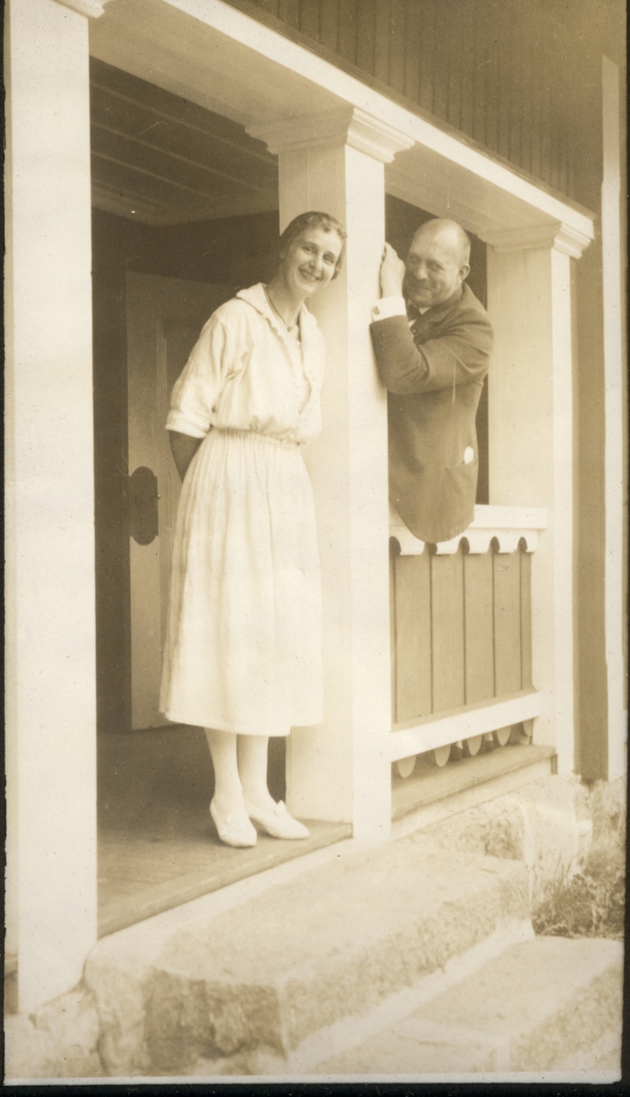Fru Lange og hr Kildahl på veranda til bolig på ukjent sted, antagelig i nærheten av Hønefoss. Fotografert 1922.