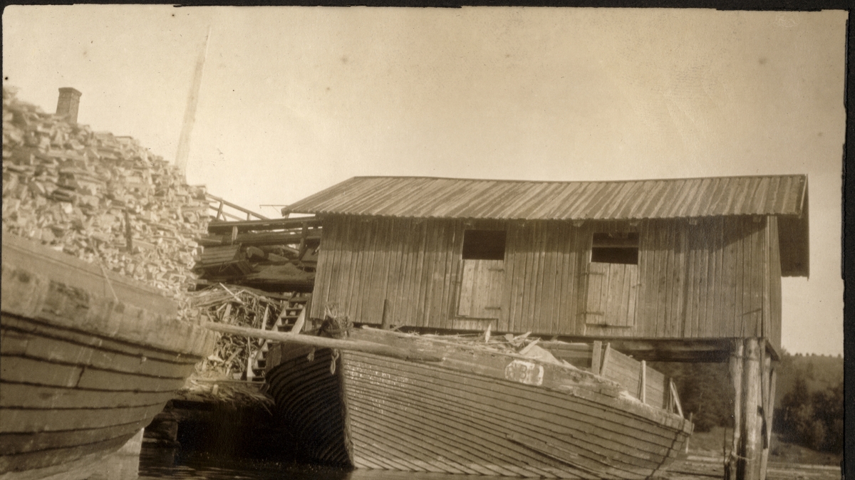 Lagerbygning og lastebåter med trelast ved Gahn Sagbruk i Fet, eid av Westye Egeberg & Co og anlagt 1882. Fotografert 1922.