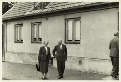 Elsa Dalman og en mann (Gøsta Dalman?) går forbi et bolighus