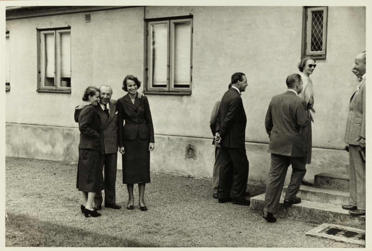 En gruppe kvinner og menn på vei inn i et bolighus. Fotografert i forbindelse med et besøk  i Sverige i 1953.