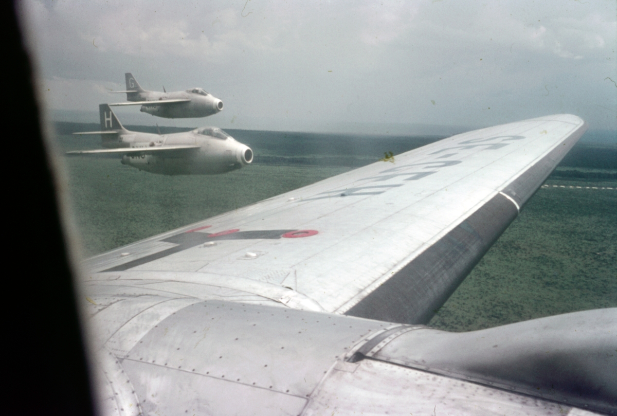 Två FN-märkta flygplan J 29 eskorterar transportflygplan Curtiss C-46 under Kongokrisen, 1962. Flygplanet tillhörde svenska Transair, med civilregistrering SE-CFH.