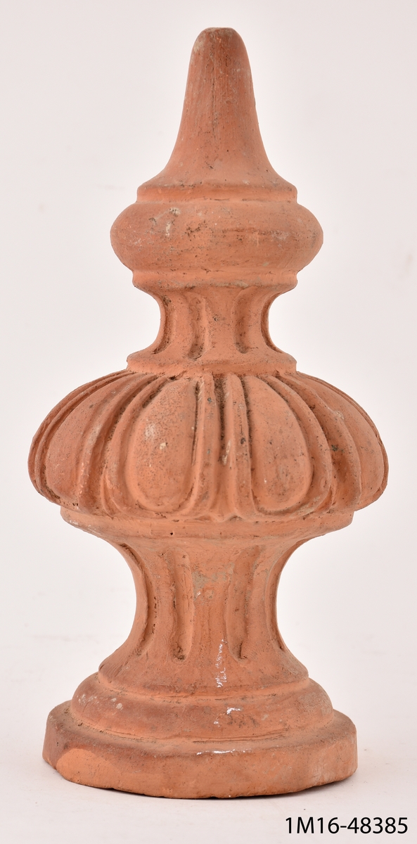 Ornament av lergods, spira, ska sitta överst på en kakelugn. Den första från Mariestads kakelfabrik.