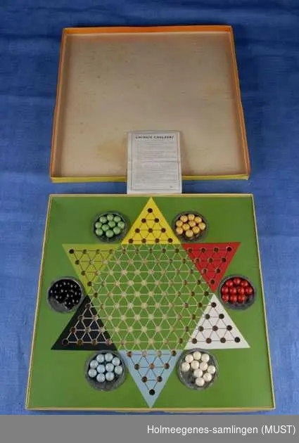 Kinasjakkspill med bruksanvisning, komplett antall kuler: 10 av hver, i 6 farger: gul, rød, svart, grønn, blå og hvit. Spillet er laget av papp, kulene er av tre.