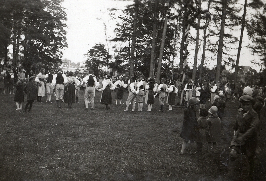 Några ungdomar i folkdräkt dansar på en äng. 
Text under fotot:" Danslaget i Boulognerskogen, midsommarafton 1931".
