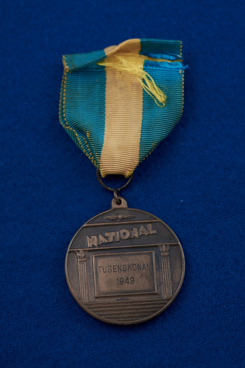 Medalj i brons fäst på blågult band. Medaljen har rund form med en naken kvinna i relief på framsidan. Medaljen var förstapriset i skönhetstävlingen "Tusensköna" på Nalen år 1949 och tilldelades Rosa Taikon. Priset var på 1000 kr.