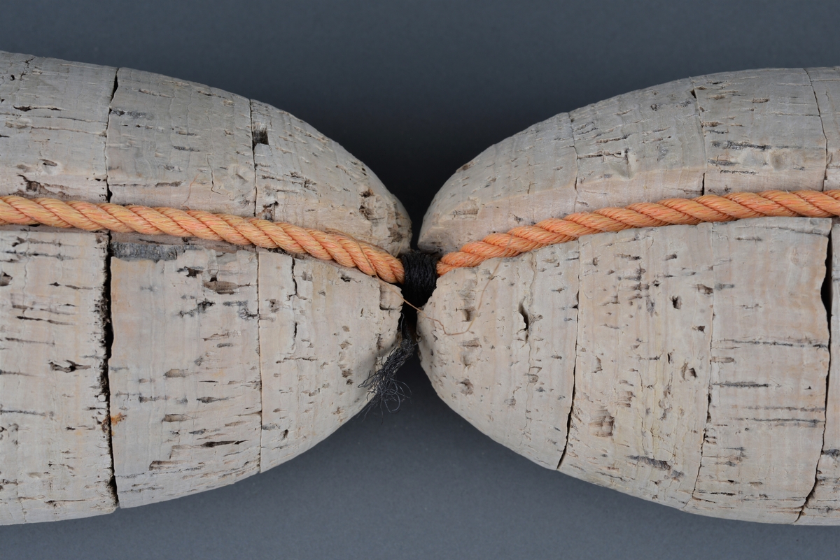 Korkflottører (2 stk) knyttet sammen med nylontau.
Begge er ovale med en langsgående rille, hvor tauet er festet.