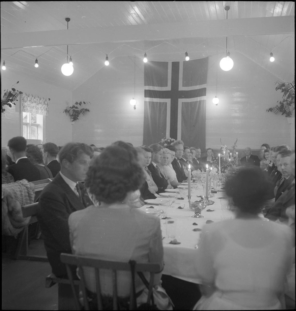 Brudeparet og gjester til bords i en bryllupsfest.