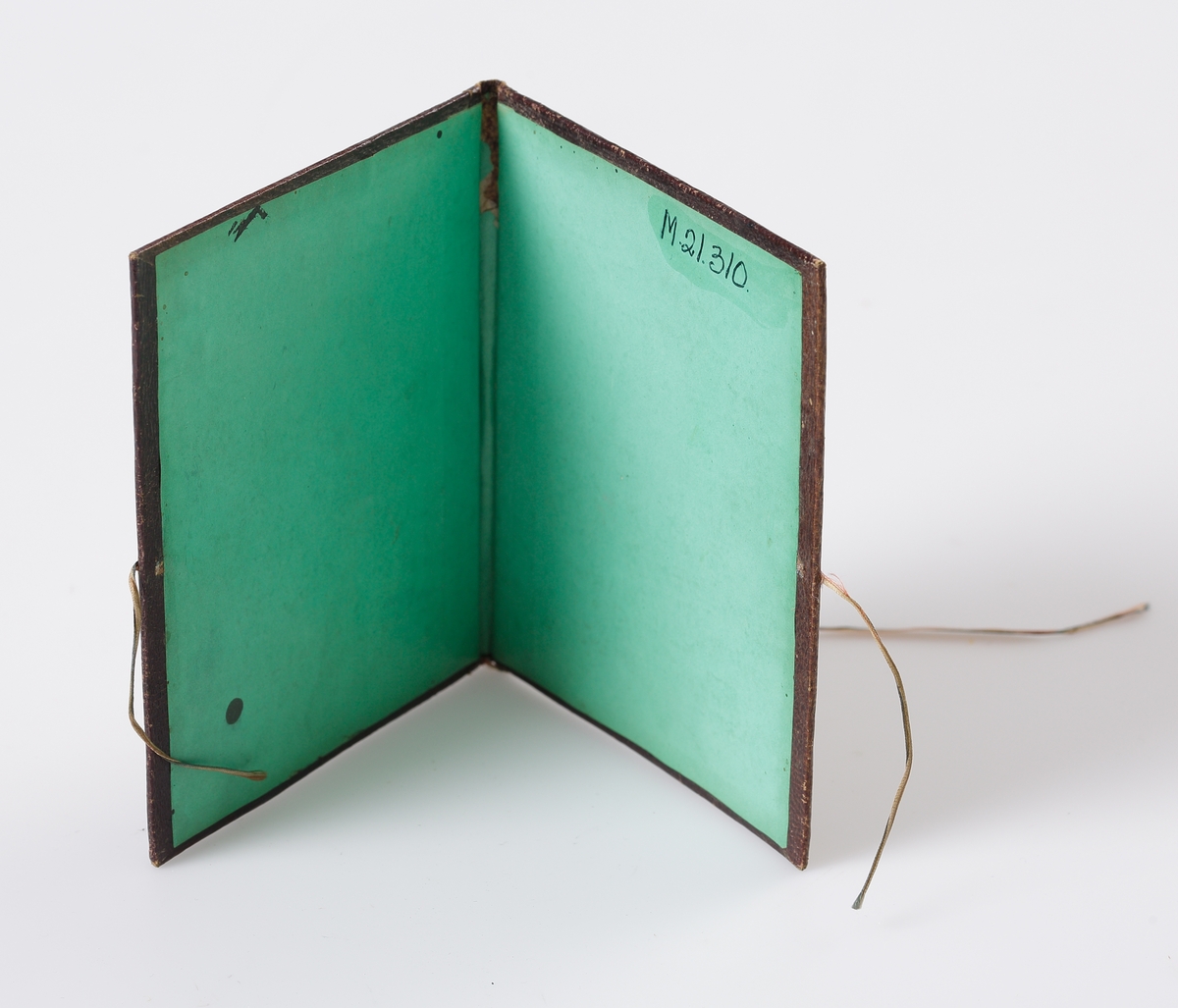 Pärm med pärlbroderi i brunt och blått.
Broderad invändigt med initialer H L (Hedvig Lindgren). Klädd med grönt papper på insidan. 

Inskrivet i huvudbok 1969.