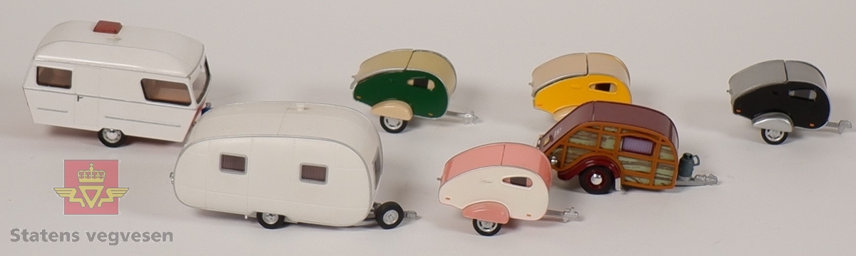 Syv miniatyrmodeller av campere/campingvogner. Fire campere har identisk form, men har forskjellige farger. To campingvogner er laget i plast, mens resterende er laget av metall. Alle sammen har innskriften HONGWELL på undersiden.