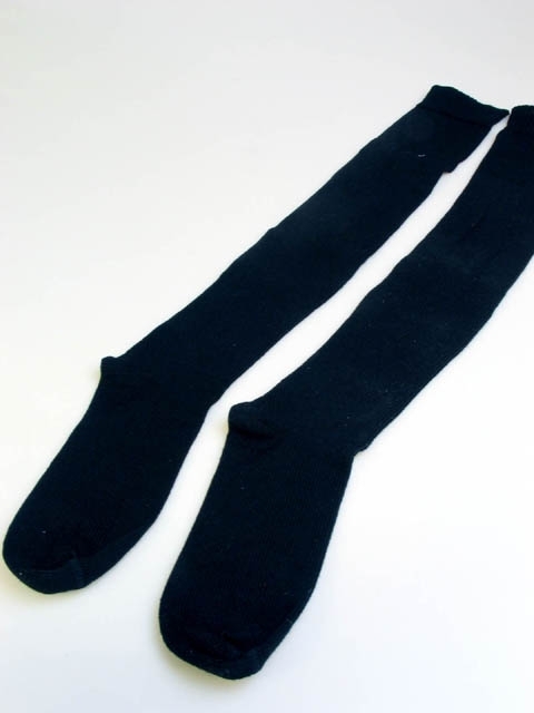 Ett par svarta stickade strumpor. Strumporna har varit utställda i basutställningen "I barnaminne" på Landskrona museum. Utställningen stod mellan 1989 och 2007.