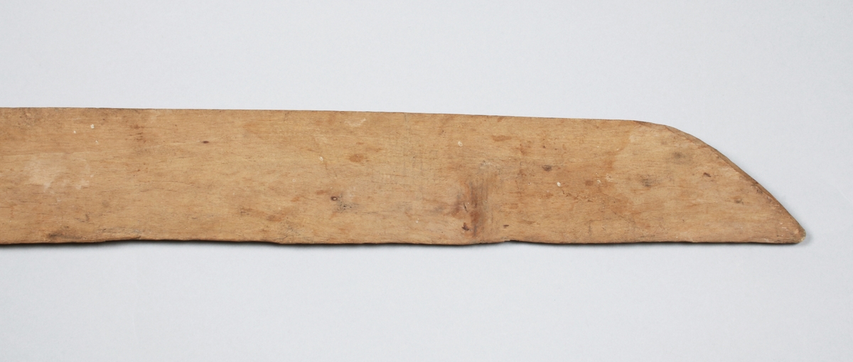 Skäktkniv i ofärgat trä. Svärdformigt, enkelt. Metallkrok för upphängning.

Funktion: Skäktkniven användes genom att lin spändes upp över en skäktstol, eller annan vertikal bräda, och därefter bearbetades linet med skäktkniven tills linet var fritt från vedämnen. (Wikipedia)
